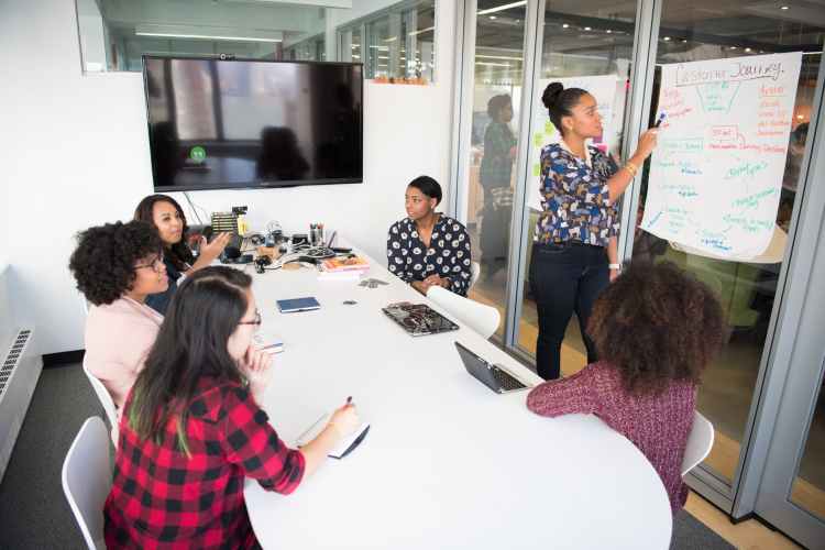 six woman standing and siting inside the room